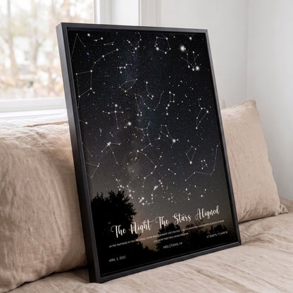 Black framed personalized Wedding Star Map displayed on a sofa with the exact night sky from a special date.