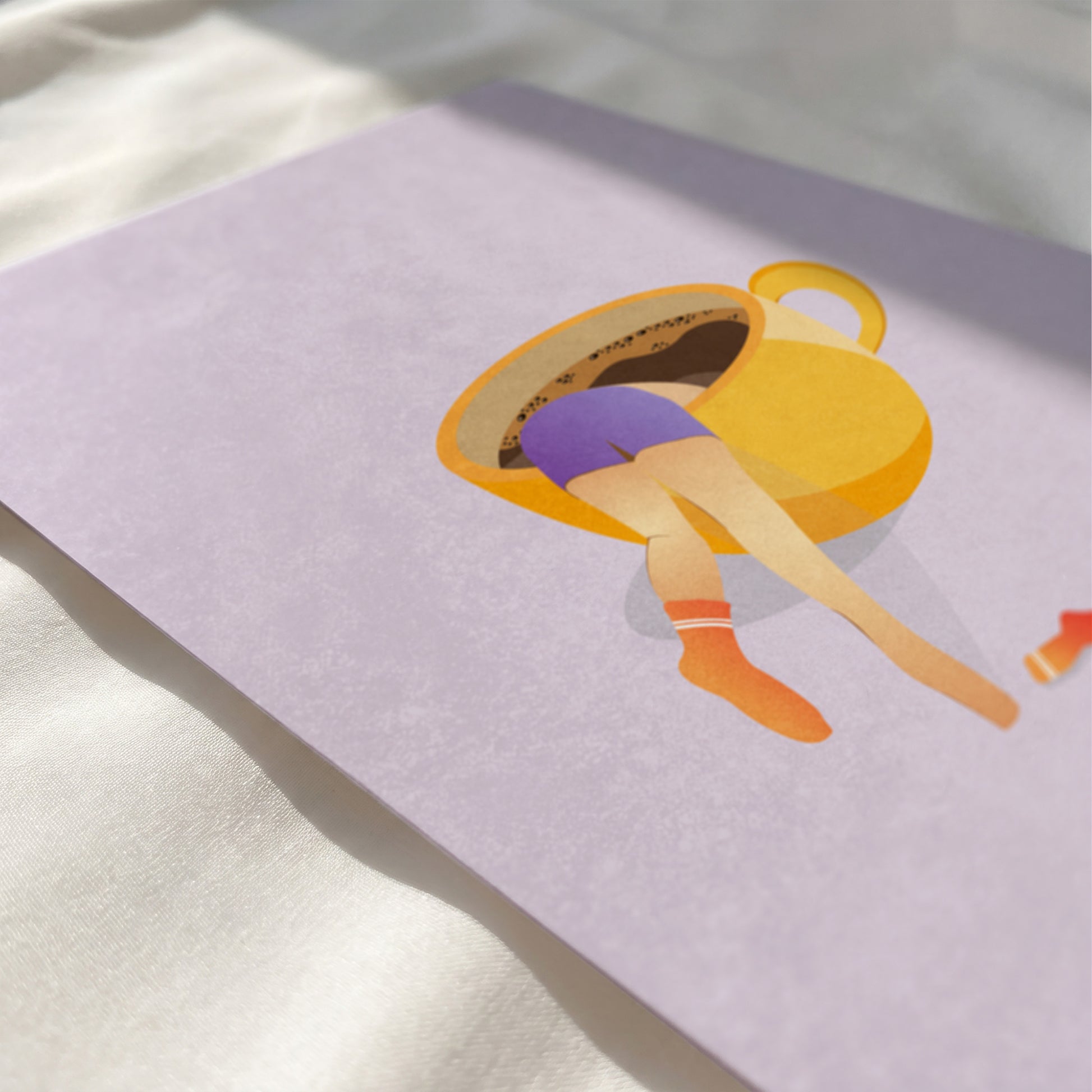 Close up view of woman diving into yellow coffee mug print showing paper texture and vibrant colors