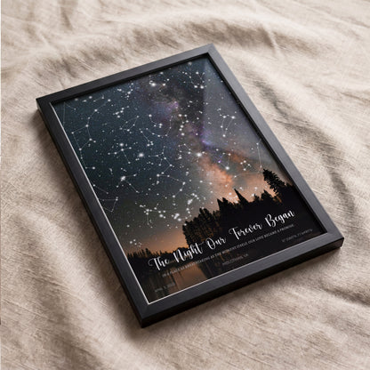Black framed custom star map poster displayed on a neutral sofa