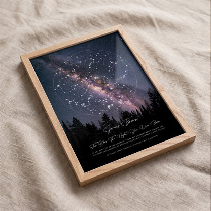 Angled view of a personalized round night sky map in a premium wooden frame on textured linen fabric.