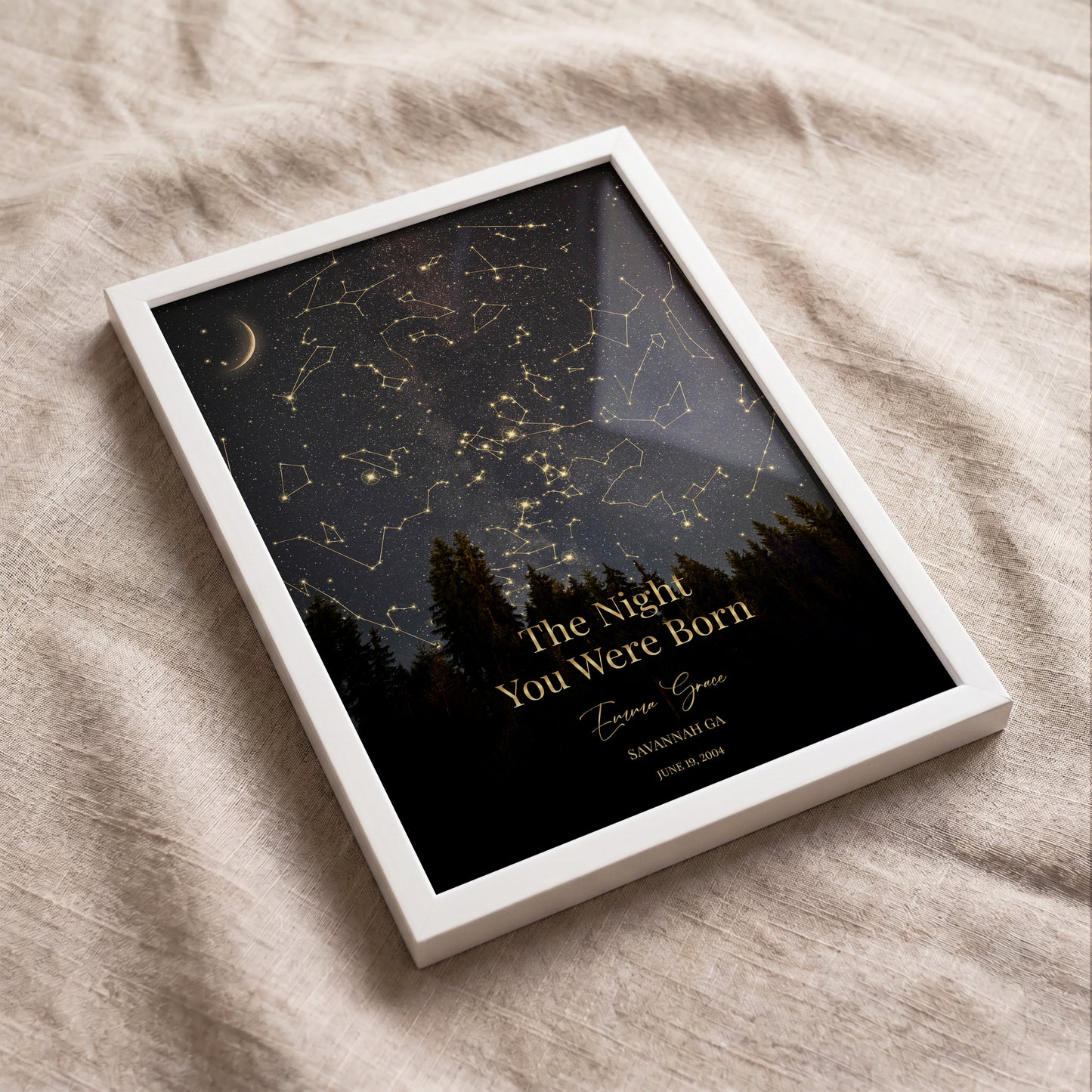 Flat lay of a personalized star map print in a white frame with a custom night sky, name, and special date.