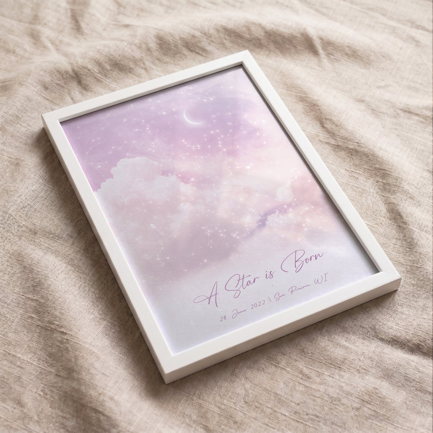 Flat lay of a personalized cloudy night sky print on soft neutral fabric.