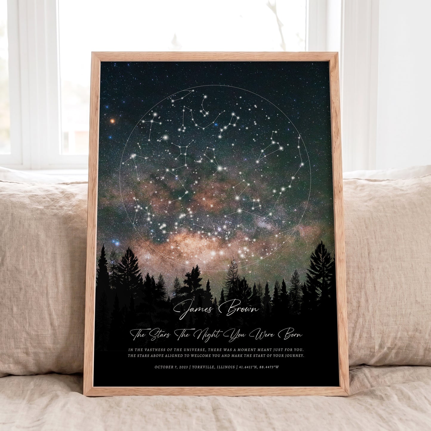 Personalized Star Map print in natural oak frame displayed on a neutral linen sofa with soft daylight.