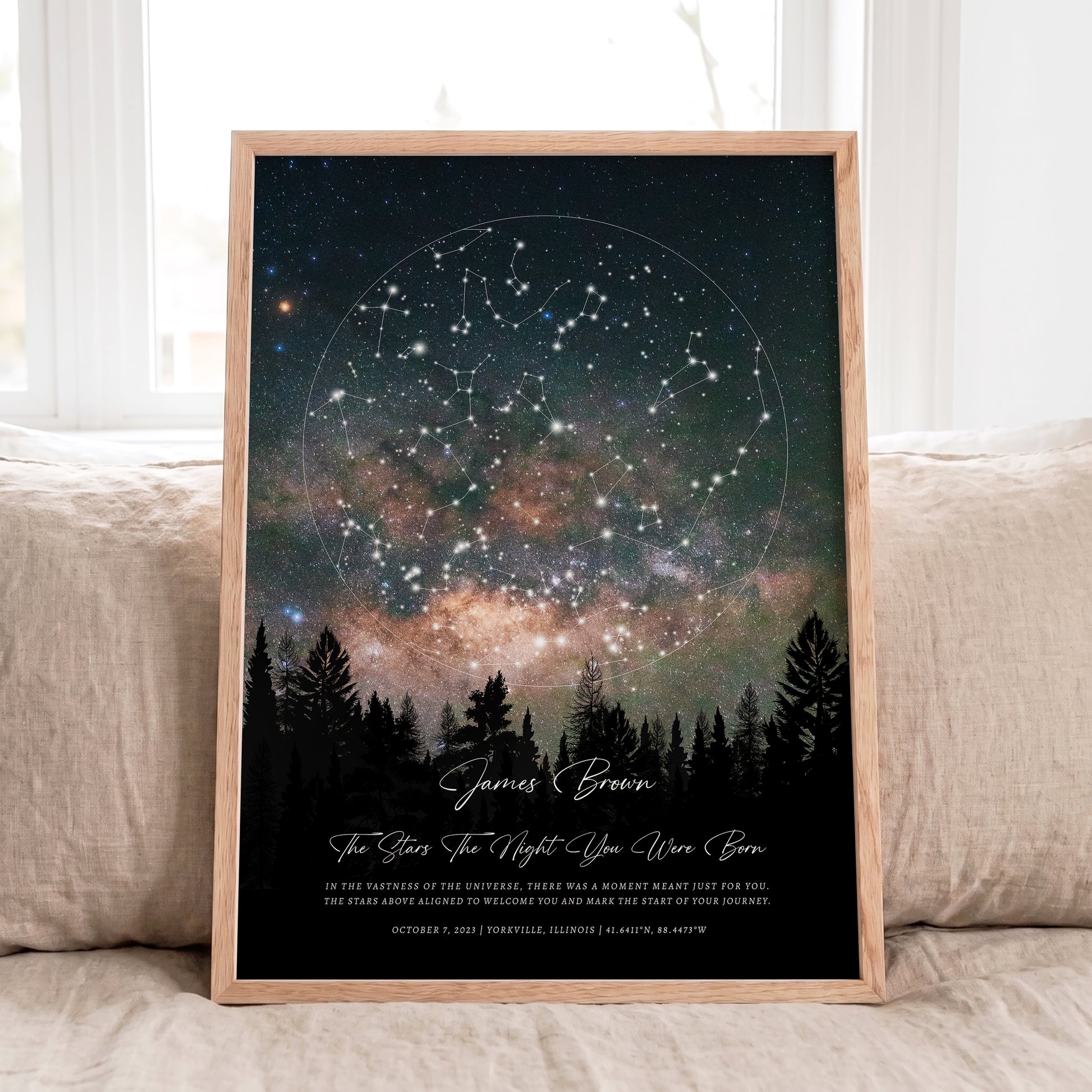 Personalized Star Map print in natural oak frame displayed on a neutral linen sofa with soft daylight.