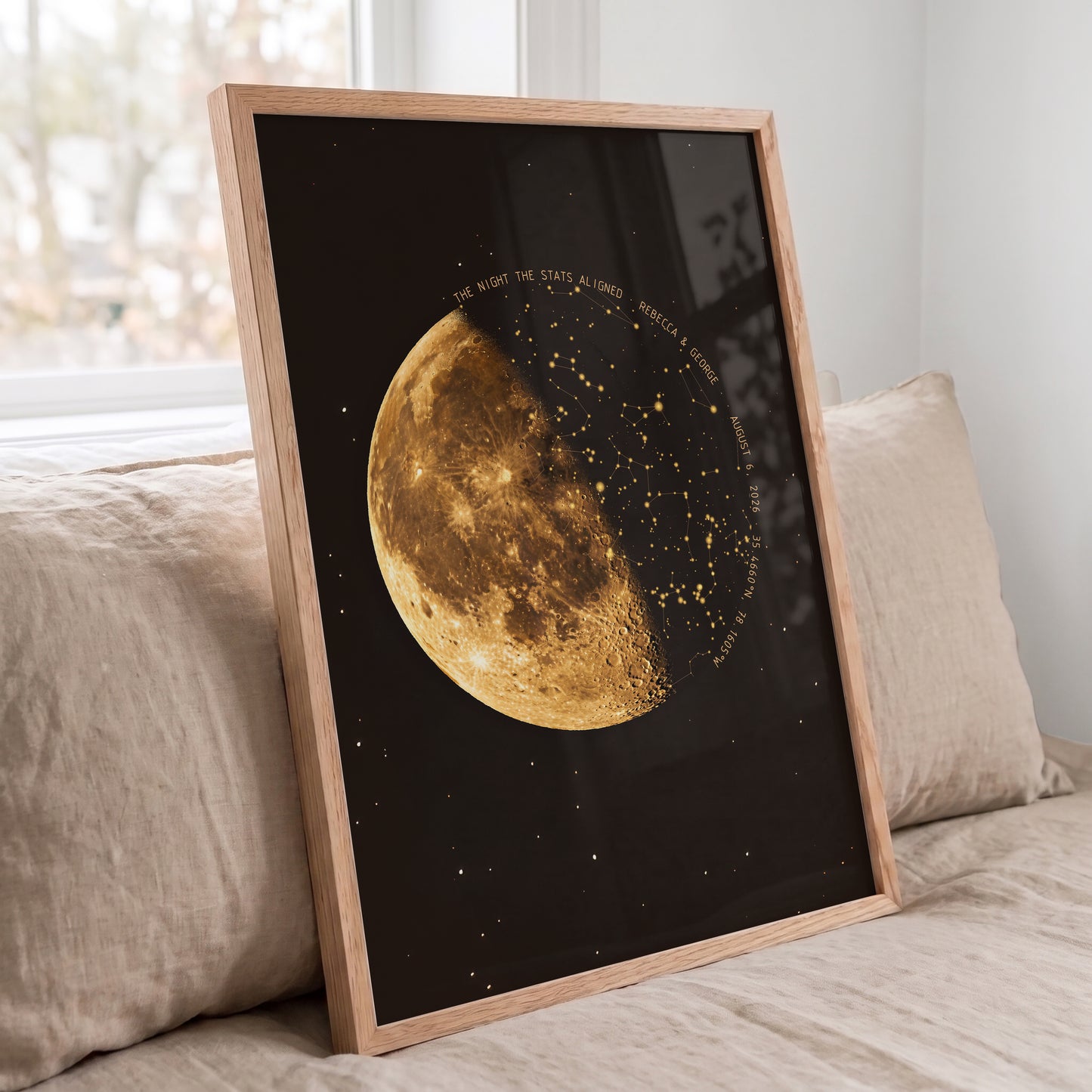 Personalized moon phase and star map displayed in a natural oak frame on a bed
