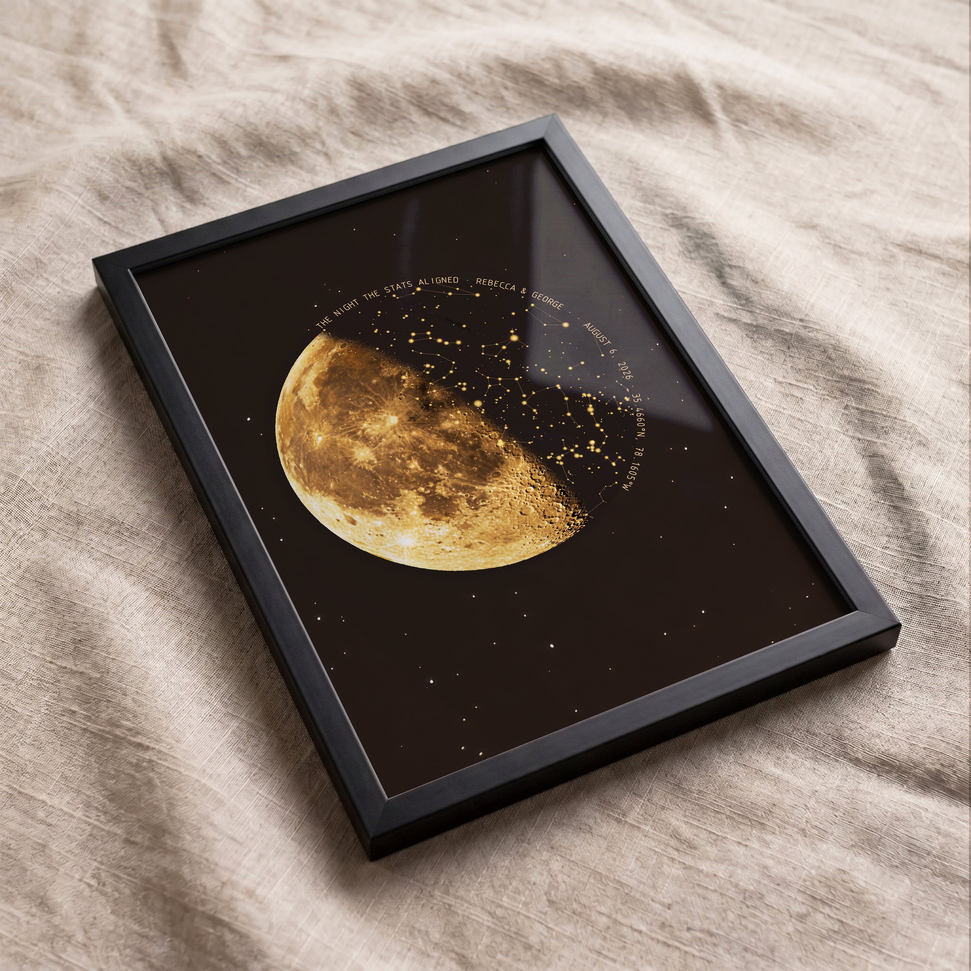 Custom moon phase star map in an oak frame styled on a cozy bedroom bed